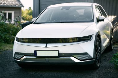 Banliyö yoluna park edilmiş beyaz elektrikli cip.