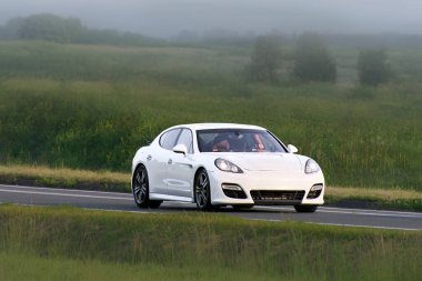 Manzarada araba süren prestij yöneticisi sedan.