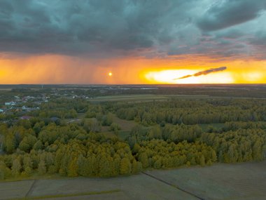 Yaklaşan fırtına bulutlarıyla kırsal arazide gün batımı