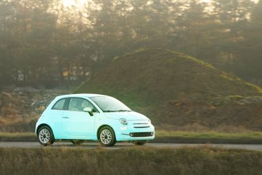 Hatchback kırsal kaldırım yolunda seyahat ediyor.