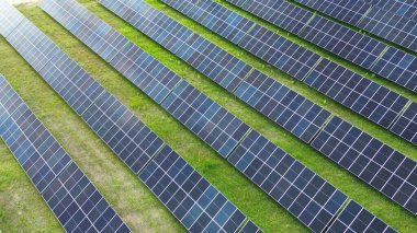 Güneş panellerinin sıraları yeşil alanda güneş ışığını yakalıyor