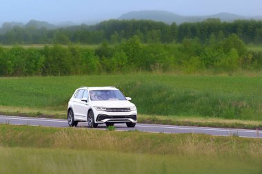 Large rugged SUV driving on quiet asphalt road