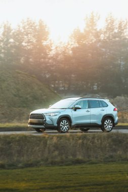 Huzurlu bir arazide lüks bir araç sürüyor.