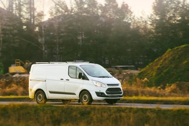 Modern minibüs güneşli bir günde seyahat ediyor.