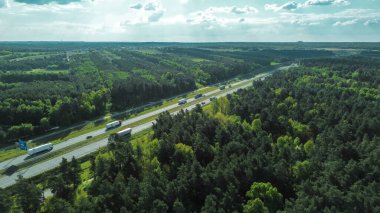 Kırsal yolda giden araba ve kamyonlar