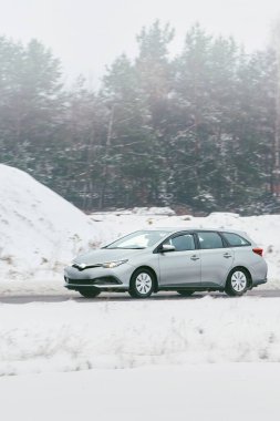 Kar altında giden kış aracı.