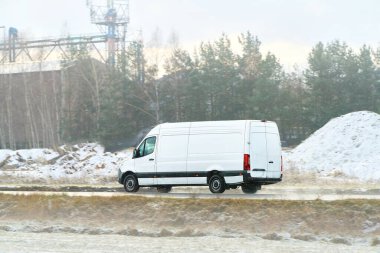 Kargo kamyonu kışın buzlu yolda ilerliyor.