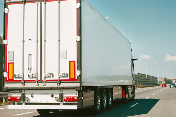 White Semi-truck on empty country road.
