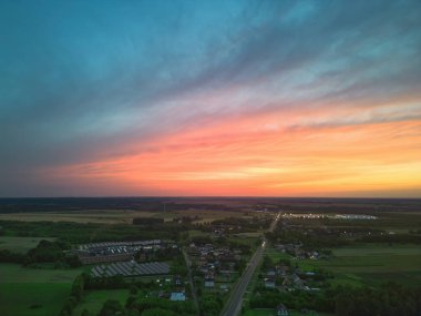 Göz kamaştırıcı bir gün batımı, yağmur ve kırsal alanda renkli gökyüzü.