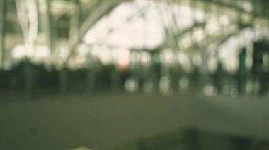 Bulanık havaalanı terminali. Yolcular yürüyor ve modern mimari soyut ve dinamik bir atmosfer yaratıyor.