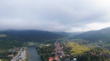 Kırsal köy ve nehir manzarası bulutların altında