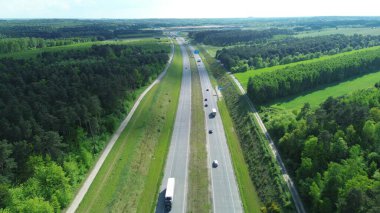Yeşil orman yolunda trafik akıyor.