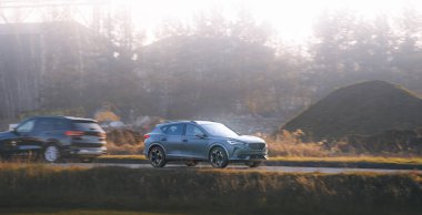 Parlak spor araba manzaralı kırsal yolda.