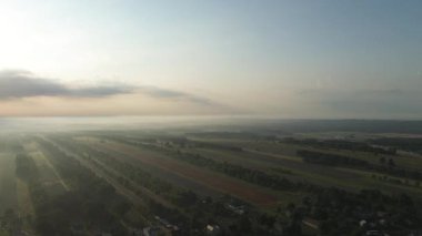 Huzurlu kırsal alanı kaplayan katmanlı sabah sisi