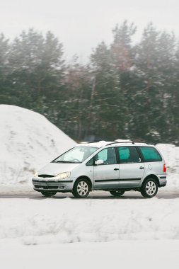 Buzlu dağ yolunda parlak küçük bir araba.