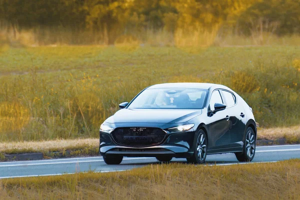 Hatchback aracı kırsal yolda ilerliyor.