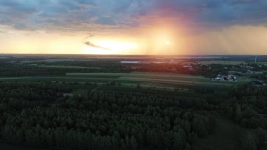 Yaklaşan fırtına bulutlarıyla kırsal arazide gün batımı