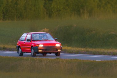 Asfalt yolda hızlı ve zarif bir eski araba.