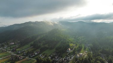 Yeşil tarlaları ve nehri olan sisli dağ vadisi