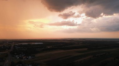 Canlı gökyüzü ve yağmur bulutlarıyla yaz akşamı günbatımı