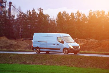 Paket teslimatı için kırsal yolda giden minibüs.