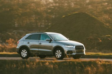 Akşam karanlığında kırsalda pahalı bir araba.