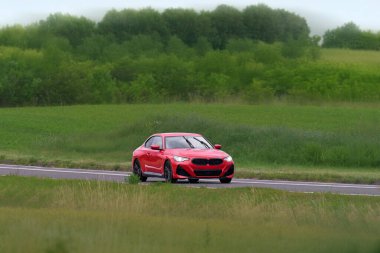 Kırsalda gezen kırmızı spor bir coupe.