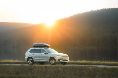 Manzaralı kırlardan geçen gümüş rengi bir SUV.