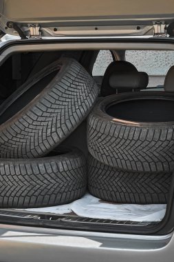 Araba bagajı kış için lastiklerle dolu.