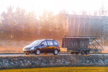 Kırsal kesimde karavan ve araba sürüyor.