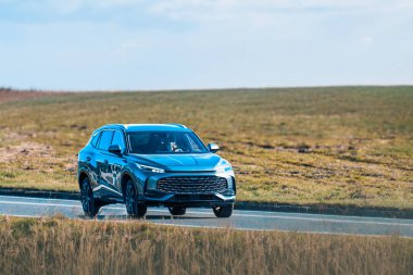 Boş köy yolunda elektrikli araba.