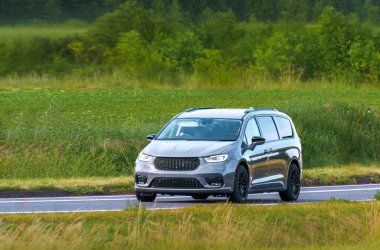 Kırsal asfalt yolda giden Avrupa MPV otomobili