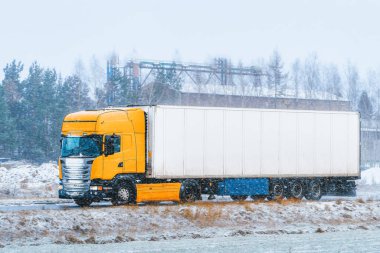 Lojistik kamyonu kış sahnesini geçiyor.