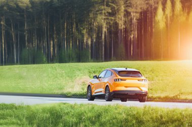 Güneşli bir günde Orman ve Tarlalardan geçen Sarı SUV