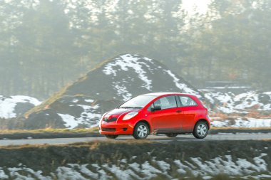 Modern kırmızı çapraz araba açık havada sürüyor.