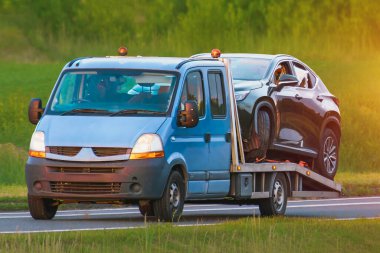 Kurtarma kamyonu bozuk arabayı dükkana taşıyor.