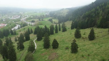 Nehir kenarındaki köy yeşil tepelerle çevrili.