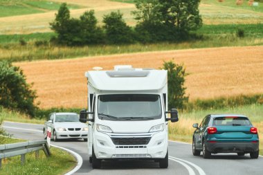 Parkın yakınındaki kırsal otobanı araştıran klasik bir karavan.