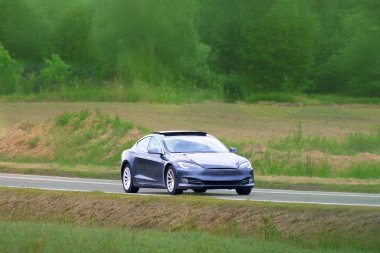 Elektrikli araba boş bir otoyolda gidiyor.