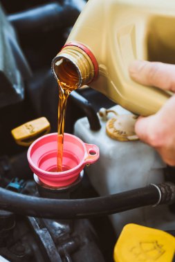 Tamirci araba motoruna sentetik yağ ekliyor