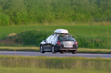 Yolda kargo kutusu olan aile arabası.