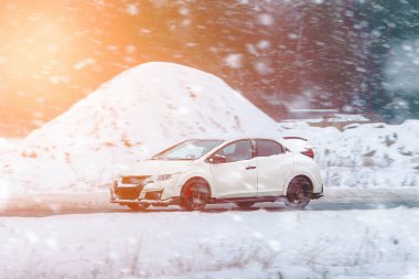 Otomobil kışın buzlu dağ yolunda yol alır