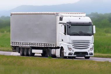 Modern lojistik karavanı güneşli otoyolda sürüyor.