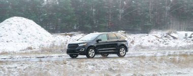 Karlı koşullarda yol alan son model bir araba.