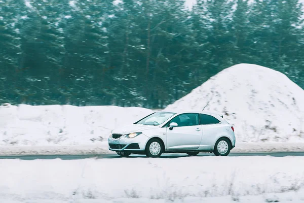 Minik arabasıyla asfalt yolda kış yolculuğu.