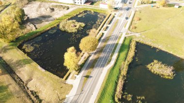 Yakınlarda su birikintileri olan kırsal alan yolu.