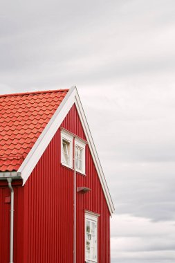 Norveç 'in sonbahar ormanlarındaki bir gölün yanındaki kırmızı kulübe.