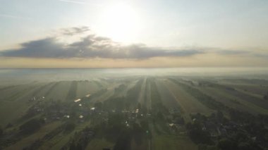 Tarımsal vadi ve tarlaların üzerinde gün doğumu sisi