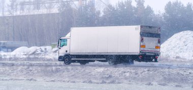 Kargo kamyonu kaygan kış yolunda.