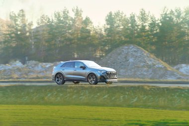 Gün batımında yeşil araziden geçen SUV